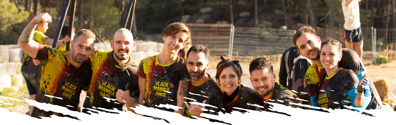 Grupo de deportistas de carrera de obstaculos con camiseta negra black mamba